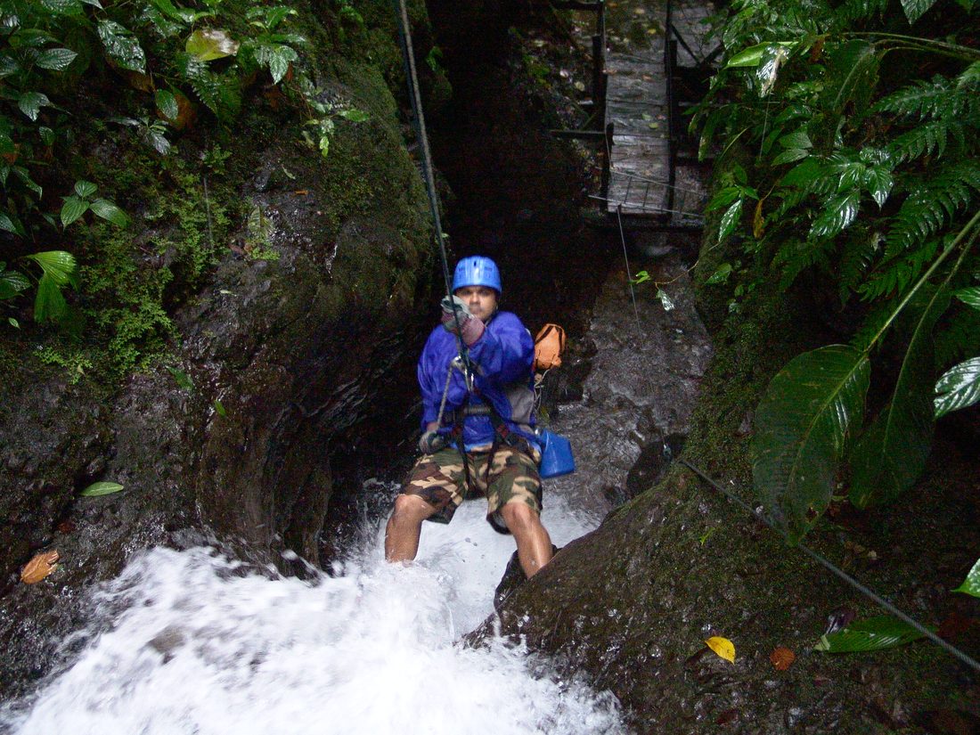 Gil rappelling down a jungle waterfall