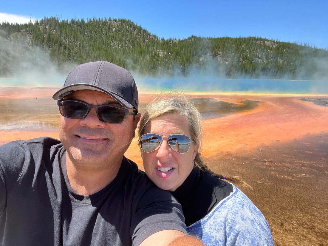 Gil and his wife in front of the Grand Prismatic Spring in Yellowstone
